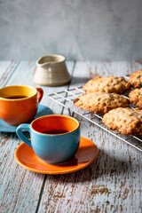 Home baked oat and raisin cookies on a wooden table with a cup of coffee