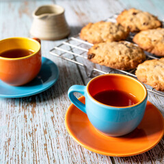 Home baked oat and raisin cookies on a wooden table with a cup of coffee