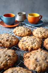 Home baked oat and raisin cookies on a wooden table with a cup of coffee