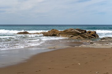 The cold Atlantic Ocean, the white foam of the waves and the golden sand of Zumaia beach