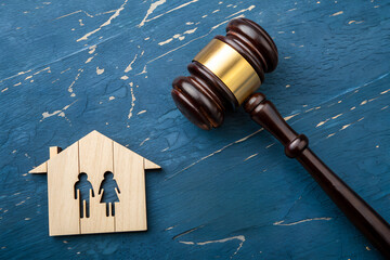 Conceptual legal image showing a judge’s gavel beside a wooden house with family figures, symbolizing family law, divorce, and justice in court decisions.