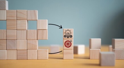 Building Blocks of Innovation: Conceptual image with wooden blocks, one of them is leading an innovative project with an idea and a target symbol. 