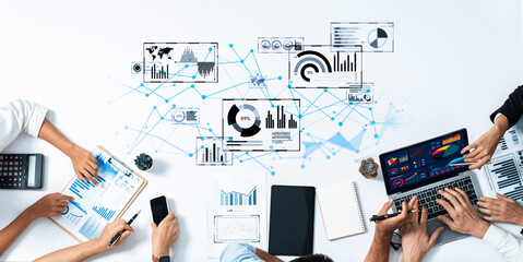 Diverse team collaborates on data analysis and business strategy, utilizing technology and visual tools in a modern office setup to enhance productivity and decision-making. Trope