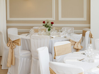 Élégante décoration de table de mariage kurde-tunisien, nappes blanches et rubans dorés dans une salle raffinée