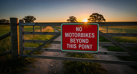 Prohibition Sign on Wooden Gate with Sunset View in Rural Meadow Setting