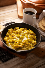 Scrambled eggs in green sauce in an cast iron skillet. A typical Mexican breakfast of scrambled eggs tossed in spicy green sauce, usually accompanied by beans and pot coffee.