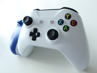 Sleek white game controller paired with blue headphones, ready for immersive gaming sessions. Ideal for gaming enthusiasts, casual players, and streamers seeking stylish, ergonomic gear for consoles © Алёна Личман