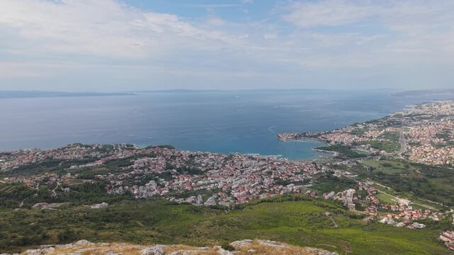 Ancient stone chapel on a coastal mountain ridge with panoramic sea view of the Dalmatian coast.
