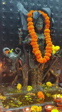 bronze statue of Shani Dev sit on bull, Hindu god of India, at night in temple.	