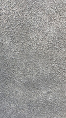 Textured gray wall surface with rough finish and subtle variations in tone and pattern