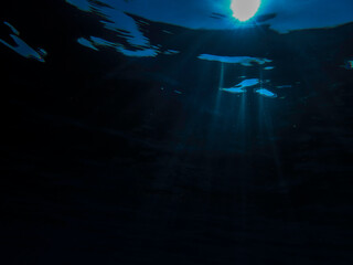 Ocean blue underwater with sunrays, Underwater Sea Deep Water Abstract Sunshine, sea wave , clean waters in summer time, Natural underwater seascape, sand on ocean floor and water surface with sunligh