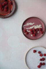 Raspberries on colorful plates © Ewa