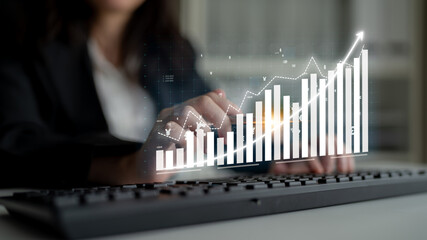 A business professional interacts with a digital display showcasing financial trends and growth,...