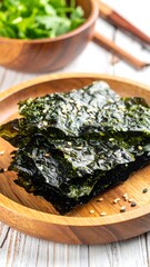 Stack of seasoned seaweed snack on wooden plate