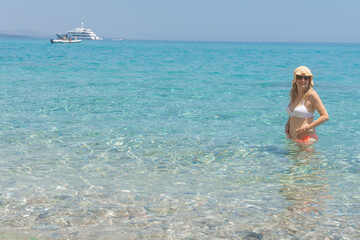 Woman in sea with yacht view, Cala Luna, Sardinia, Italy