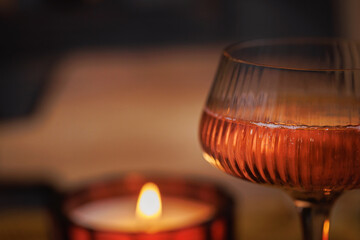 Rose wine in coupe glass with soft candlelight in warm fall setting