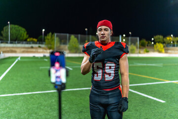 Football player filming content during night game