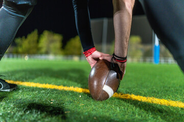 Football player setting ball on field for kickoff