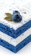 Stacked, layered square elements adorned with fresh blueberries and leaf