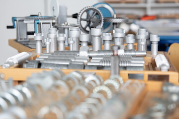 Reihen von metallischen Bauteilen sind gleichm&auml;&szlig;ig in einer Werkstatt oder Produktionsumgebung angeordnet. Das Motiv steht f&uuml;r industrielle Fertigung, Ordnung und pr&auml;zise Serienproduktion.