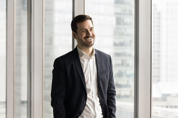 Portrait handsome young businessman posing in office with happy smile