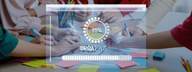 A vibrant workspace featuring diverse hands engaged in a group project. A digital interface indicates progress, surrounded by colorful stationery and creative materials. Trope