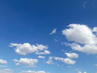 Innocent Cumulus Clouds in Bright Blue Sky.