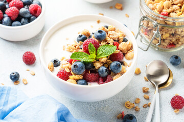 Yogurt with fresh berries in white bowl.