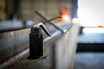 Close up of an oil can on a steel beam in a workshop.