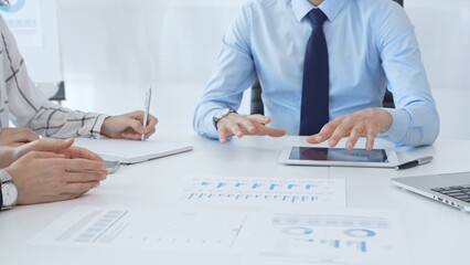 Business people reviewing financial metrics on digital screens, collaborating strategically while...