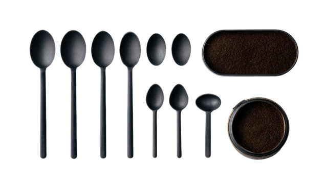 Black spoons and coffee grounds in oval trays