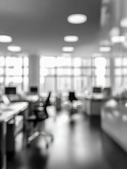 Fototapeta premium Blurred view of a modern open office space with desks, chairs, and computers illuminated by bright ceiling lights and natural daylight through large windows