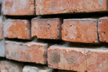 Capture the timeless beauty of an old brick wall up close, with its weathered texture and visible signs of age and construction details, ideal for conveying history, texture, and rugged charm.
