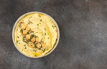 Lupin hummus or turmeric hummus with olive oil and herbs on a gray background. Top view. copy space.