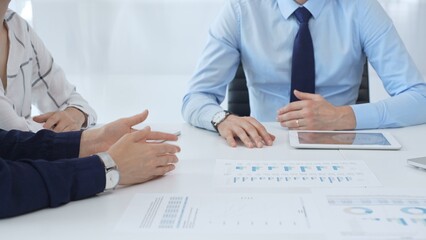 Business people reviewing financial metrics on digital screens, collaborating strategically while examining charts and graphs in office