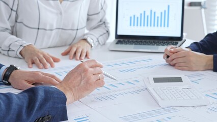 Business people analyzing financial data and market trends during a corporate meeting, collaborating on reports and planning strategic growth in modern office
