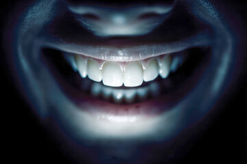 Naklejka premium Mysterious glowing smile in the dark with illuminated teeth creating an eerie and captivating facial expression close-up photograph