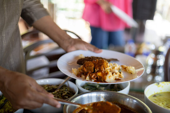 Person Serving Traditional Indian Kerala Curry and Kappa Cassava