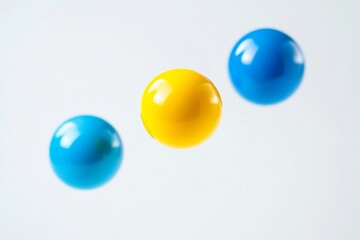 Vibrant yellow and blue spheres floating on white background