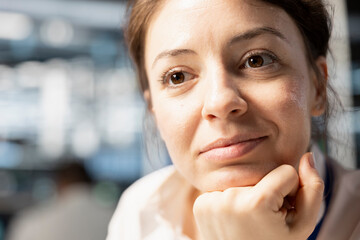 Close up of smiling data center IT professional monitoring system performance, identifying bottlenecks. Upbeat woman in server farm troubleshooting computer bugs, implementing optimizations