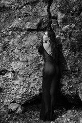 Portrait of woman in bikini on tropical beach near the mountain. Back view