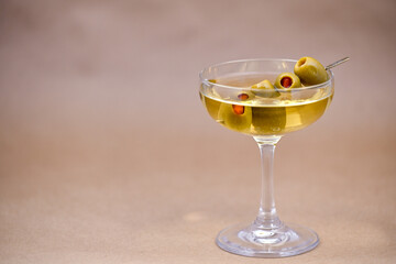 Classic Martini Cocktail with Green Olives in Coupe Glass on Neutral Background