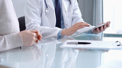 Doctor is consulting patient. Healthcare professional discusses medical information with a woman,...