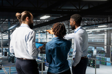 Data center staff on industrial platform collaborating to maintain servers using artificial intelligence. Engineers doing teamwork to support infrastructure AI deep learning automatization.