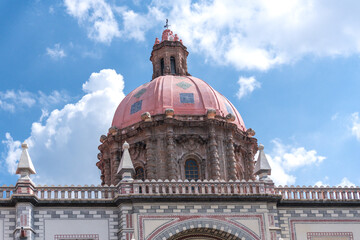 Obraz premium A large building with a red dome on top. The building is surrounded by a railing. Historic center of Queretaro, colonial architecture, decorations for the celebration of Mexico's Independence Day.