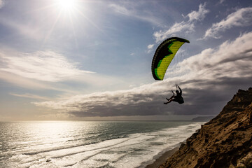 Extreme paragliding pilot soaring in the New Zealand beach. Adventure concept