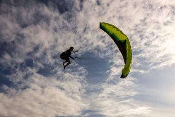 Extreme paragliding pilot soaring in the New Zealand beach. Adventure concept