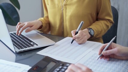 Businesswoman or professional auditor is analyzing data on laptop. Close-up of female bookkeeper analyzing financial documents,close up. Business concept