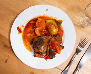 Delicious baked pork cheek served on platter with vegetables and potatoes