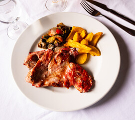 Delicious baked pork served with french fries and vegetables